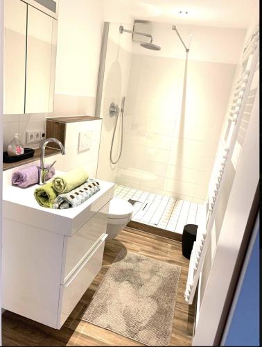 a white bathroom with a shower and a toilet at Großartige Wohnung mit großem Garten in Bad Schwartau! in Bad Schwartau