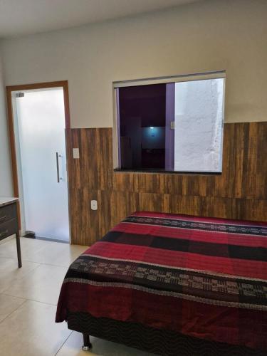 a bedroom with a bed and a tv on the wall at Apartamento Studio in Diamantina