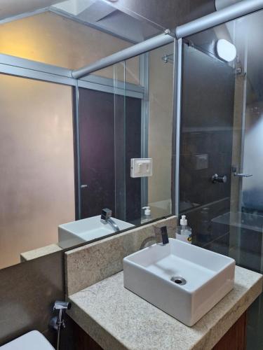 a bathroom with a white sink and a mirror at Apartamento Studio in Diamantina