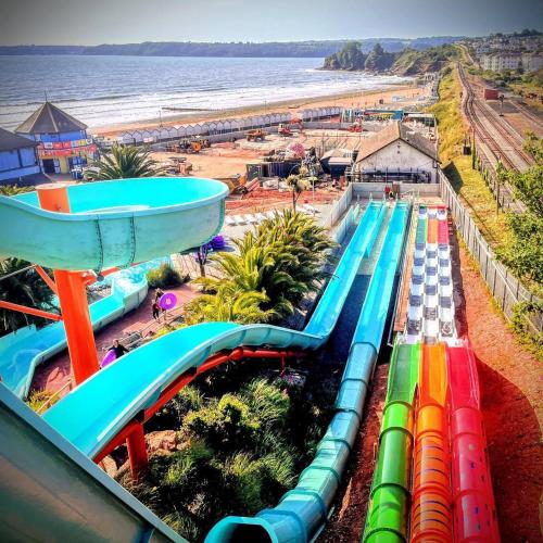 an amusement park with a water slide next to the beach at Cherwood Guest House in Paignton