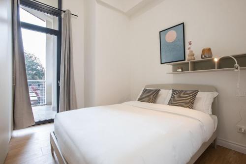 a white bedroom with a bed and a window at Urban Oasis near Termini, Free Parking&Balcony, int10 in Rome
