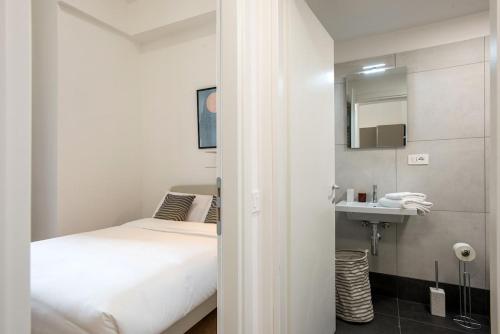 a white bedroom with a bed and a sink at Urban Oasis near Termini, Free Parking&Balcony, int10 in Rome