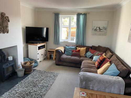 a living room with a couch and a tv at 2 Fernleigh Villas in Perranporth
