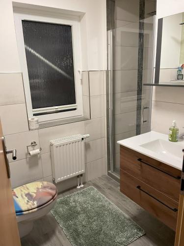 a bathroom with a sink and a toilet and a window at Zimmer in Hafennähe in Dierhagen