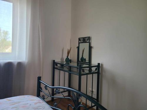 a mirror and vases on a shelf next to a bed at Appartement F4 Suite Giulia in Auboué