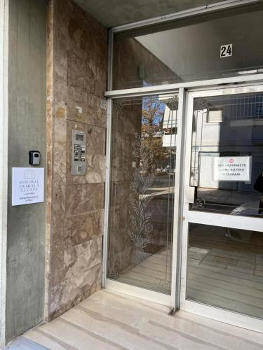 a glass door of a building with a sign on it at Minimal Trikala Escape in Tríkala