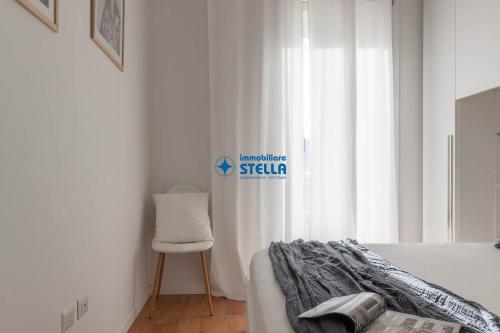 a bedroom with a bed and a chair next to a window at Wave Island in Lido di Jesolo