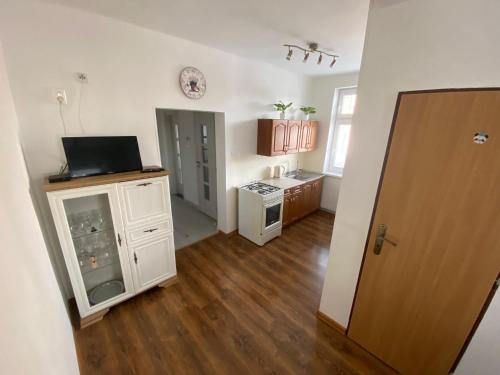 a room with a kitchen with white cabinets and a door at Lomnica Lodge in Vysoké Tatry