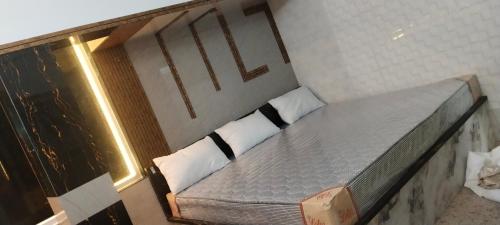 a bed in a room with two pillows on it at AK Beach House in Velankanni