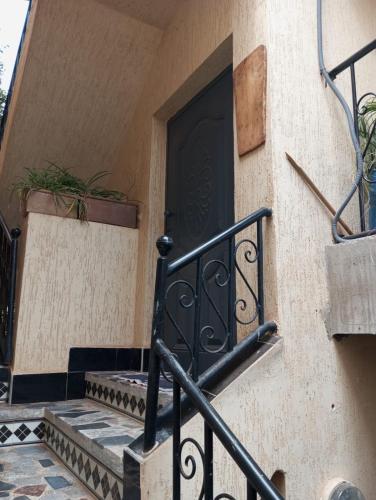 a black door on the side of a building with stairs at Riad Targante Takate 2 in Takkat