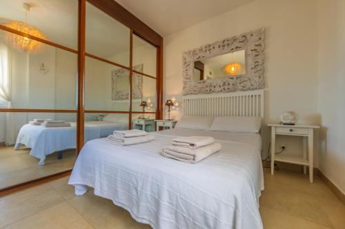 sypialnia z białym łóżkiem i ręcznikami na nim w obiekcie Sol y Mar - by Tarifa Rent - Jacuzzi OPTIONAL for extra fee w mieście Tarifa