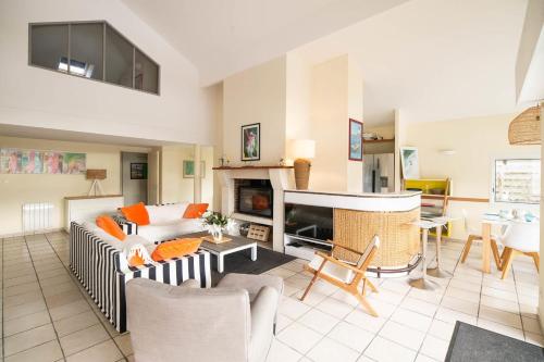 a living room with a couch and a fireplace at Villa 145 m near ocean with pool and garden in Moliets-et-Maa