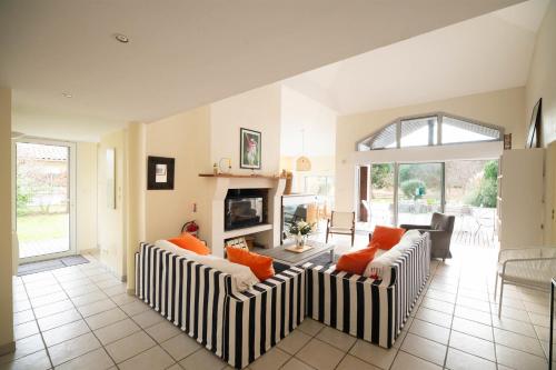 a living room with two couches and a fireplace at Villa 145 m near ocean with pool and garden in Moliets-et-Maa