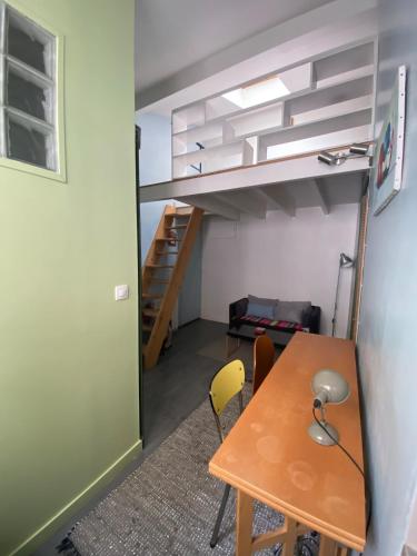 Cette petite chambre comprend une table et des lits superposés. dans l'établissement Paris 19 Studio mezzanine,calme,ensoleillé, à Paris