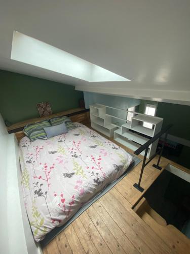 une chambre avec un grand lit et un bureau dans l'établissement Paris 19 Studio mezzanine,calme,ensoleillé, à Paris