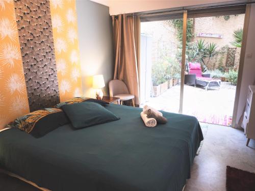 - un ours en peluche assis sur un lit dans une chambre dans l'établissement Grande et belle chambre d'hôte avec jardin, au Cannet