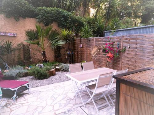 d'une terrasse avec une table et des chaises dans le jardin. dans l'établissement Grande et belle chambre d'hôte avec jardin, au Cannet