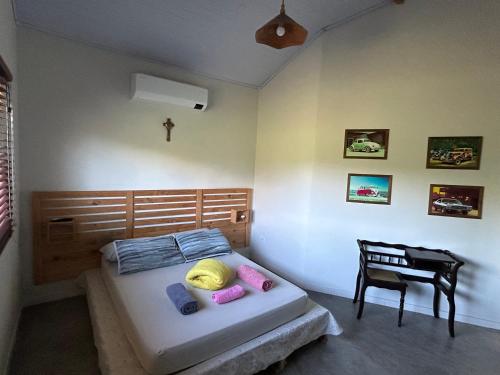 a bedroom with a bed and a chair and a desk at Casa de Campo à beira rio in Morretes