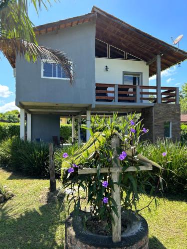 a house with purple flowers in front of it at Casa de Campo à beira rio in Morretes
