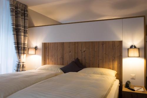 a bedroom with two beds and two lights on at Hotel La Romantica in Le Prese, Poschiavo