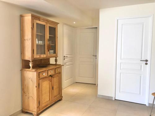 - une cuisine avec une armoire en bois et une porte dans l'établissement The HoPe, suite privée au sein d'une maison avec piscine, à Aix-en-Provence