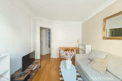 un salon avec un canapé blanc et une table dans l'établissement Flexliving - Onebedroom - Bréguet, à Paris