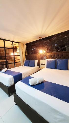 two beds in a hotel room with two bedsvisor at Andaliving Campo Valdés in Medellín