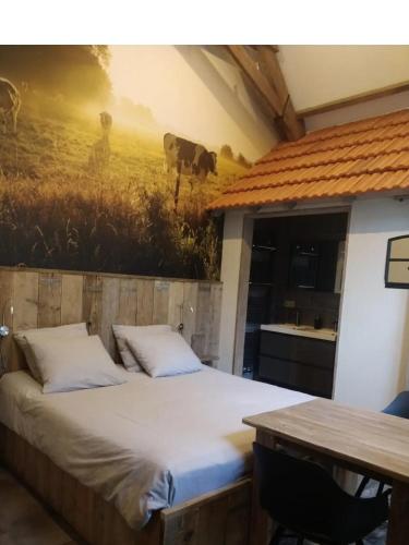 a bed in a room with a painting on the wall at Erve Toon'boer in Mander