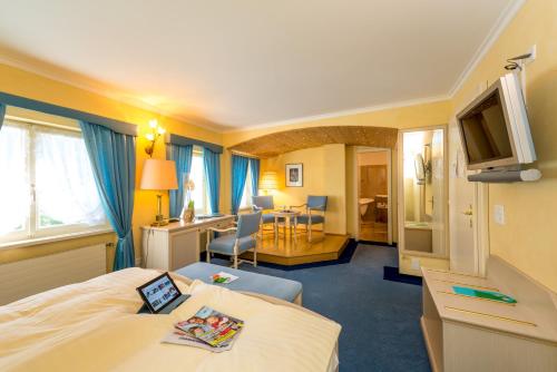 a hotel room with a bed and a living room at Hotel La Romantica in Le Prese, Poschiavo