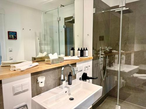 ein Badezimmer mit Waschbecken und Dusche in der Unterkunft FIRST im FIRST Sellin, Penthouse Meer & Meer mit phänomenalem Ostseeblick in Ostseebad Sellin