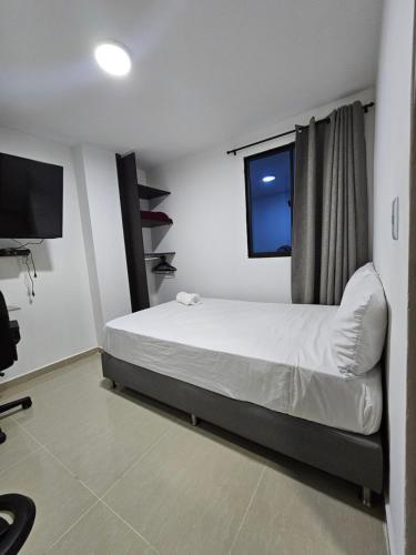 a bedroom with a bed and a flat screen tv at Andaliving Campo Valdés in Medellín
