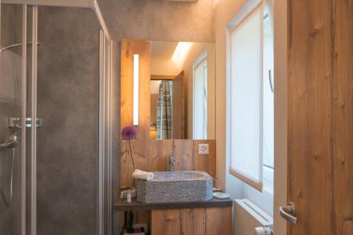 a bathroom with a sink and a mirror at Hotel La Romantica in Le Prese, Poschiavo