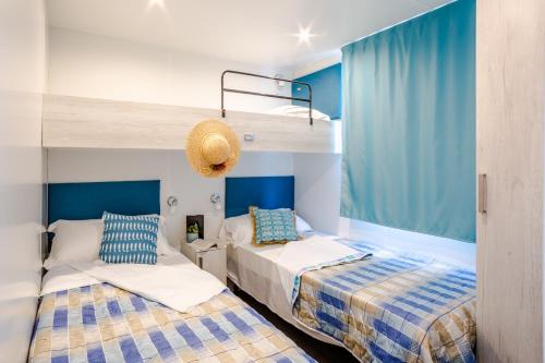 two beds in a room with a bunk bed at Centro Vacanze Camping Spinnaker in Marina Palmense