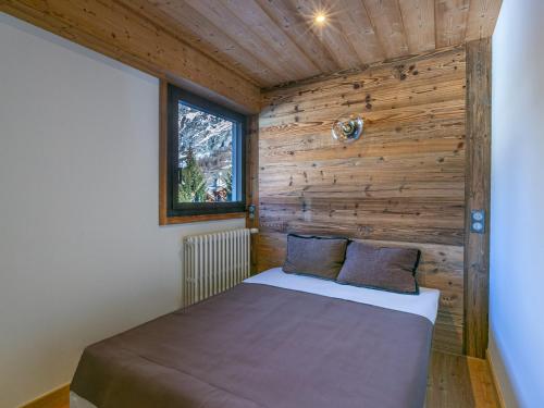 un lit dans une chambre avec un mur en bois dans l'établissement Appartement haut de gamme, 4 pers, wifi - FR-1-694-370, à Val dʼIsère