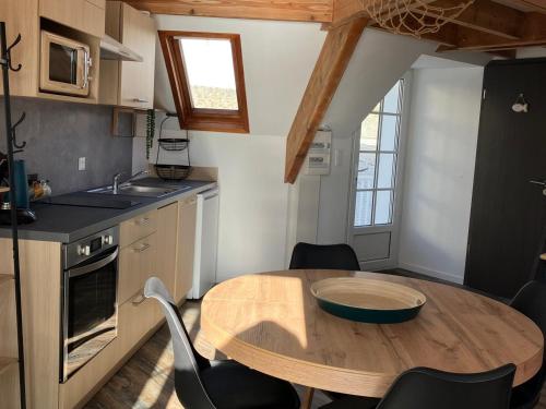 une cuisine avec une table en bois et une petite table et des chaises dans l'établissement Appartement au coeur de Sauzon avec vue sur port, près de la plage, Wifi - FR-1-418-257, à Sauzon