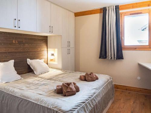 a bedroom with a large bed with two brown towels on it at Chalet triplex à Val Thorens - 10 pers, cheminée, à 50m des pistes - FR-1-637-83 in Val Thorens
