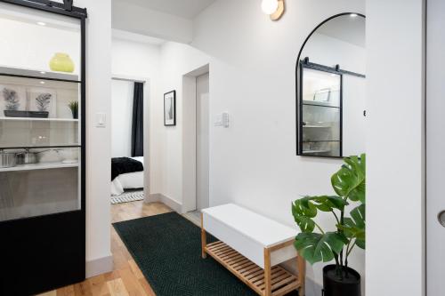 a living room with a white bench and a green rug at Les Residences Saint Laurent- Parc Mont Royal in Montréal