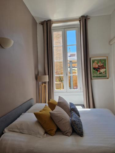 une chambre avec un lit avec des oreillers et une fenêtre dans l'établissement Superbe 2 pièces avec grande terrasse, classé ***, à Marseille