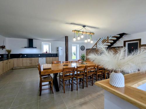 une cuisine et une salle à manger avec une table et des chaises en bois dans l'établissement Grand Gîte en Berry avec Jardin, Jeux et Parking - FR-1-591-714, à Le Lys-Saint-Georges