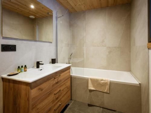 une salle de bain avec une baignoire et un lavabo et une baignoire tubermottermott dans l'établissement Chalet en triplex pour 14 personnes avec Wifi, parking et terrasse - FR-1-263-546, à Valloire