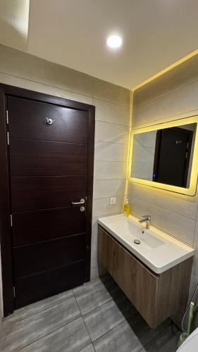 a bathroom with a sink and a black door at Elysium Luxury 1Bed Apartment! Opposite to Centaurus Mall in Islamabad