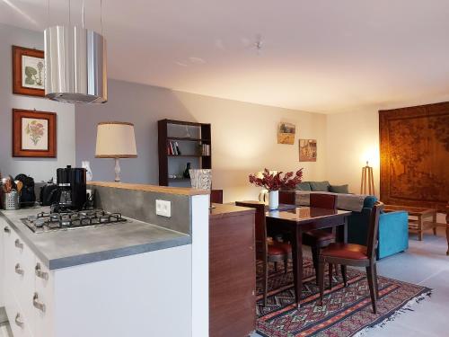 Il comprend une cuisine et un salon avec un comptoir et une table. dans l'établissement Gîte charmant avec jardin clos et parking à Saint-Sauveur-Marville - FR-1-581-146, à Saint-Sauveur-Marville