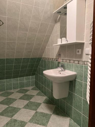 bagno con lavandino e parete piastrellata verde di Villa Bella a Špindlerův Mlýn