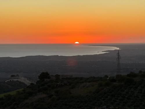 a sunset over the ocean with the sun in the sky at Villa Nadore in Caltabellotta