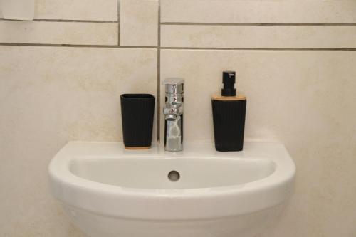 a white sink with two cups on top of it at Tygerviews on Uys in Tygerberg Hills