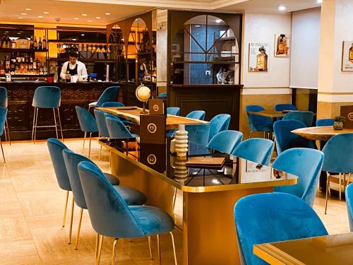 a restaurant with blue chairs and a bar at Just Hotel Saronno in Saronno
