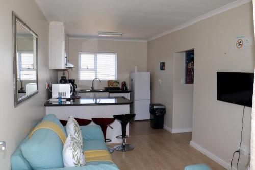 a living room with a couch and a kitchen at Tygerviews on Uys in Tygerberg Hills