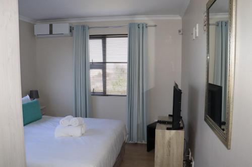 a room with two beds and a television and a mirror at Tygerviews on Uys in Tygerberg Hills