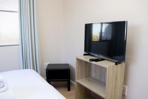 a bedroom with a tv on a wooden stand at Tygerviews on Uys in Tygerberg Hills