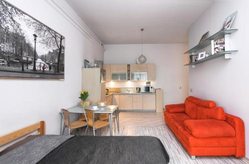 a living room with a red couch and a table at Abra 2 Apartments in Krakow